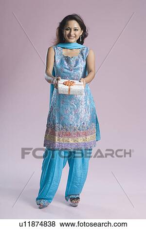 Portrait of a mid adult woman in salwar kameez and holding a gift box View Large Photo Image Stock Photo - Portrait of a mid adult woman in salwar kameez and holding a gift box. Fotosearch