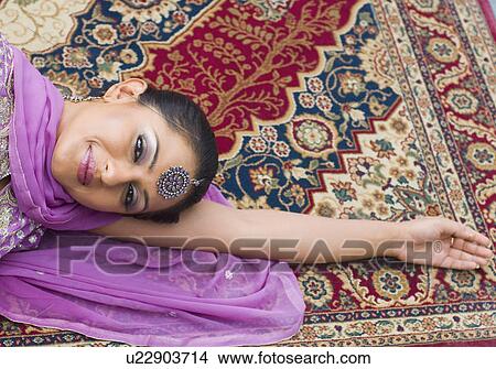 Portrait of a mid adult woman lying on a carpet in salwar kameez View Large Photo Image Picture - Portrait of a mid adult woman lying on a carpet in salwar kameez. Fotosearch