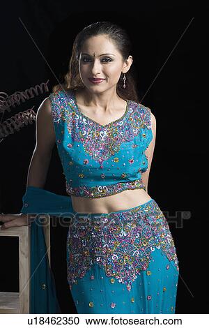 Portrait of a mid adult woman standing in lehenga choli View Large Photo Image Stock Image - Portrait of a mid adult woman standing in lehenga choli. Fotosearch