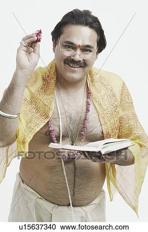Portrait of a priest holding a book and flower petals View Large Photo Image Stock Image - Portrait of a priest holding a book and flower petals. Fotosearch