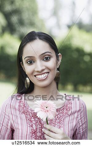Portrait of a teenage girl holding a flower View Large Photo Image Picture - Portrait of a teenage girl holding a flower. Fotosearch
