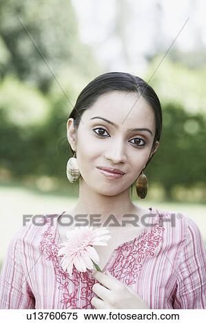 Stock Photography - Portrait of a teenage girl holding a flower. Fotosearch