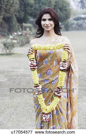Portrait of a young woman holding a garland View Large Photo Image Stock Photo - Portrait of a young woman holding a garland. Fotosearch