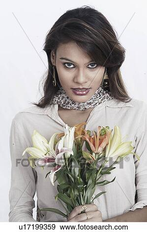 Portrait of a young woman holding a bunch of flowers View Large Photo Image Stock Photo - Portrait of a young woman holding a bunch of flowers. Fotosearch