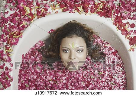 Portrait of a young woman lying in a bathtub with flower petals floating View Large Photo Image Stock Image - Portrait of a young woman lying in a bathtub with flower petals floating. Fotosearch