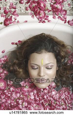 Portrait of a young woman lying in a bathtub with flower petals floating View Large Photo Image Stock Photography - Portrait of a young woman lying in a bathtub with flower petals floating. Fotosearch