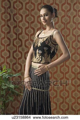 Portrait of a young woman standing in lehenga choli View Large Photo Image Picture - Portrait of a young woman standing in lehenga choli. Fotosearch