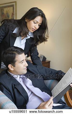 Businessman with his assistant reading a file View Large Photo Image Stock Image - Businessman with his assistant reading a file. Fotosearch