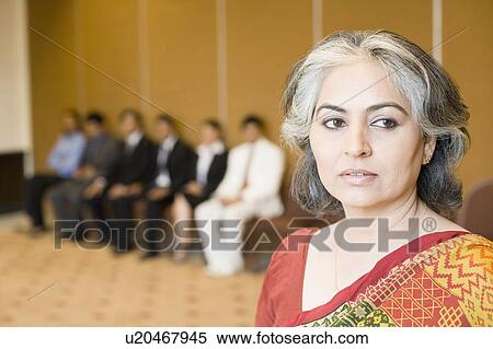 Close-up of a businesswoman with her colleagues in the background View Large Photo Image Stock Photography - Close-up of a businesswoman with her colleagues in the background. Fotosearch