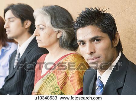 Four business executives sitting in a conference room View Large Photo Image Stock Image - Four business executives sitting in a conference room. Fotosearch