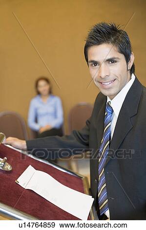 Portrait of a businessman standing at a podium and smiling View Large Photo Image Stock Photo - Portrait of a businessman standing at a podium and smiling. Fotosearch