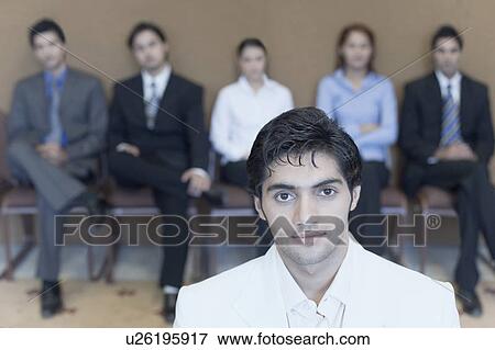 Portrait of a businessman with his colleagues in the background View Large Photo Image Stock Photo - Portrait of a businessman with his colleagues in the background. Fotosearch