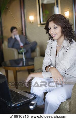 Portrait of a businesswoman sitting in an armchair and smiling View Large Photo Image Stock Photography - Portrait of a businesswoman sitting in an armchair and smiling. Fotosearch