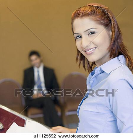 Portrait of a businesswoman standing at a podium and smiling View Large Photo Image Stock Image - Portrait of a businesswoman standing at a podium and smiling. Fotosearch