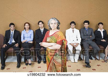 Portrait of a businesswoman standing in front of a group of business executives View Large Photo Image Stock Image - Portrait of a businesswoman standing in front of a group of business executives. Fotosearch