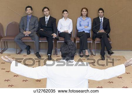 Rear view of a businessman giving speech in a seminar View Large Photo Image Stock Photography - Rear view of a businessman giving speech in a seminar. Fotosearch