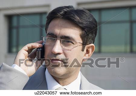 Close-up of a businessman talking on a mobile phone View Large Photo Image Stock Photo - Close-up of a businessman talking on a mobile phone. Fotosearch