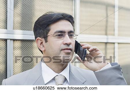 Stock Photography - Close-up of a businessman talking on a mobile phone. Fotosearch