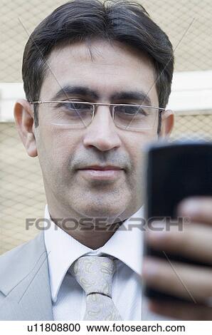 Close-up of a businessman text messaging on a mobile phone View Large Photo Image Stock Image - Close-up of a businessman text messaging on a mobile phone. Fotosearch