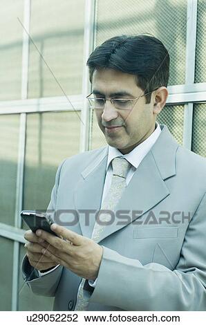 Close-up of a businessman text messaging on a mobile phone View Large Photo Image Stock Image - Close-up of a businessman text messaging on a mobile phone. Fotosearch