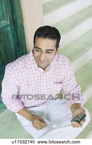 Stock Photography - Close-up of a young man holding a mobile phone. Fotosearch