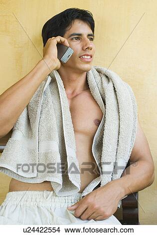Close-up of a young man talking on a mobile phone View Large Photo Image Picture - Close-up of a young man talking on a mobile phone. Fotosearch