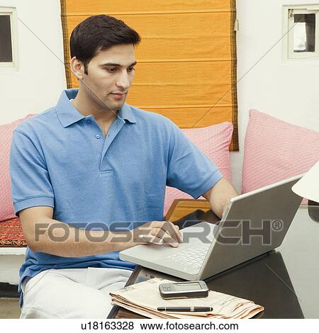 Stock Photo - Close-up of a young man using a laptop. Fotosearch