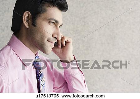 Side profile of a businessman talking on a mobile phone View Large Photo Image Stock Photography - Side profile of a businessman talking on a mobile phone. Fotosearch