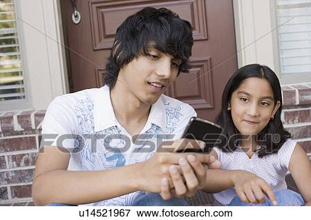 Stock Photo - Teenage boy sitting with his sister. Fotosearch