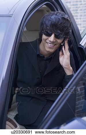 Teenage boy talking on a mobile phone in a car View Large Photo Image Stock Image - Teenage boy talking on a mobile phone in a car. Fotosearch