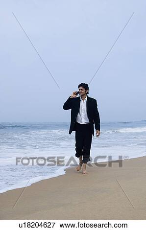 Stock Photo - Young man talking on a mobile phone. Fotosearch