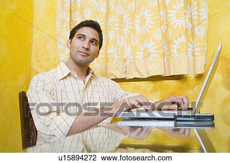 Young man using a laptop and thinking View Large Photo Image Stock Image - Young man using a laptop and thinking. Fotosearch