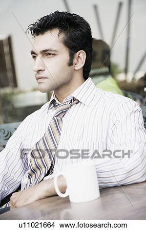 Close-up of a businessman sitting in a restaurant and thinking View Large Photo Image Picture - Close-up of a businessman sitting in a restaurant and thinking. Fotosearch