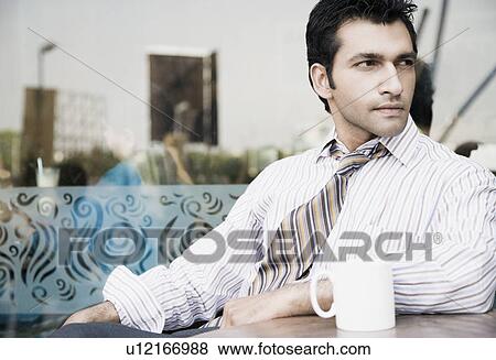 Close-up of a businessman sitting in a restaurant View Large Photo Image Stock Photo - Close-up of a businessman sitting in a restaurant. Fotosearch