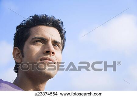 Close-up of a young man looking away View Large Photo Image Picture - Close-up of a young man looking away. Fotosearch
