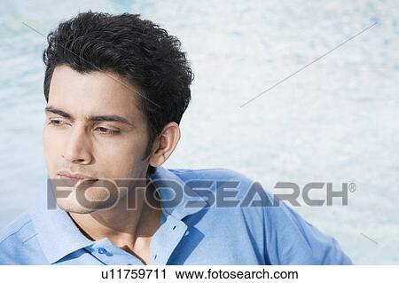Close-up of a young man looking away View Large Photo Image Stock Image - Close-up of a young man looking away. Fotosearch