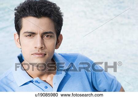 Stock Image - Portrait of a young man at the poolside. Fotosearch