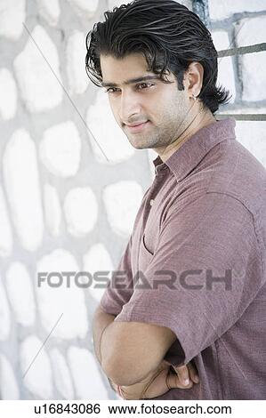 Side profile of a young man standing with his arms crossed View Large Photo Image Stock Photograph - Side profile of a young man standing with his arms crossed. Fotosearch
