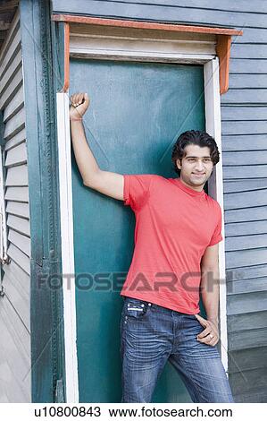 Young man leaning against a closed door View Large Photo Image Stock Image - Young man leaning against a closed door. Fotosearch