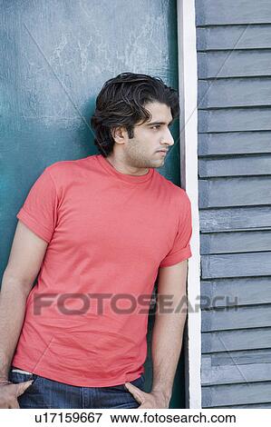 Young man leaning against a door View Large Photo Image Stock Photo - Young man leaning against a door. Fotosearch