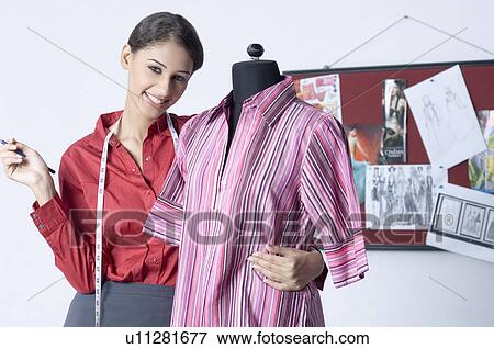 Portrait of a female fashion designer standing with a mannequin View Large Photo Image Stock Photo - Portrait of a female fashion designer standing with a mannequin. Fotosearch