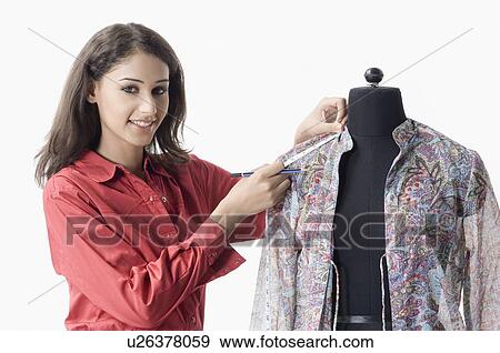 Portrait of a female fashion designer measuring the sleeve of a shirt View Large Photo Image Stock Photo - Portrait of a female fashion designer measuring the sleeve of a shirt. Fotosearch