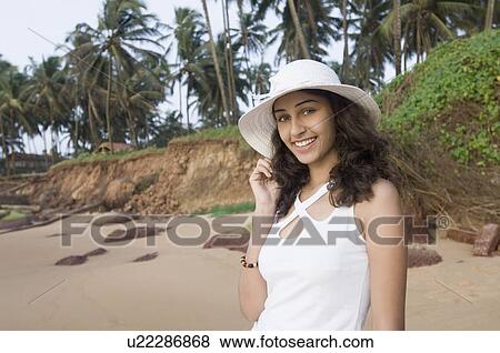 Portrait of a young woman standing on the beach and smiling, Goa, India View Large Photo Image Stock Photo - Portrait of a young woman standing on the beach and smiling, Goa, India. Fotosearch