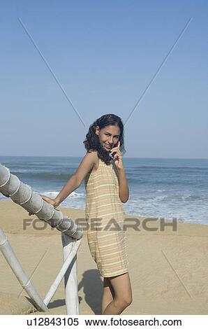 Young woman talking on a mobile phone and smiling View Large Photo Image Stock Photography - Young woman talking on a mobile phone and smiling. Fotosearch