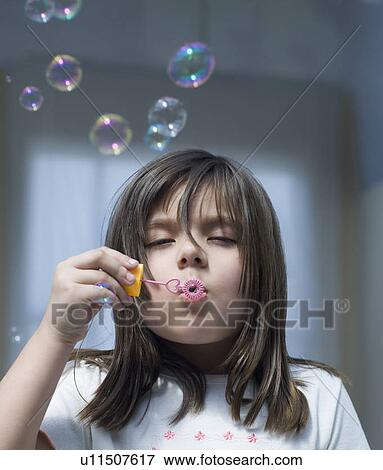 Close-up of a girl blowing bubbles with a bubble wand View Large Photo Image Stock Photo - Close-up of a girl blowing bubbles with a bubble wand. Fotosearch