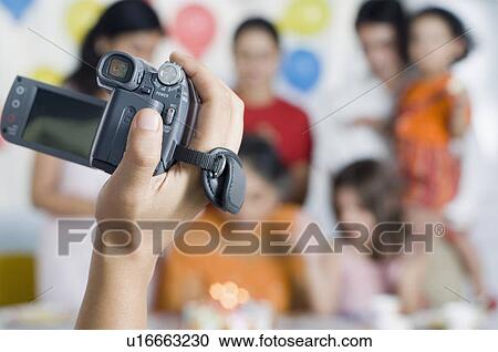 Close-up of a person's hand filming birthday party with a home video camera View Large Photo Image Stock Image - Close-up of a person's hand filming birthday party with a home video camera. Fotosearch