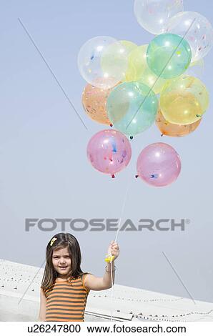 Girl holding balloons and smiling View Large Photo Image Stock Image - Girl holding balloons and smiling. Fotosearch