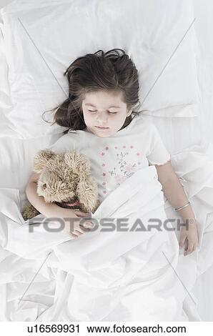 High angle view of a girl sleeping on the bed View Large Photo Image Stock Image - High angle view of a girl sleeping on the bed. Fotosearch