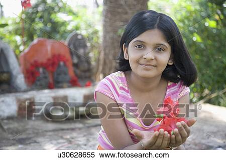 Stock Photography - Portrait of a girl holding a hibiscus. Fotosearch