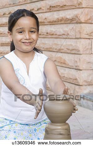 Stock Photograph - Portrait of a girl making a pottery and smiling. Fotosearch